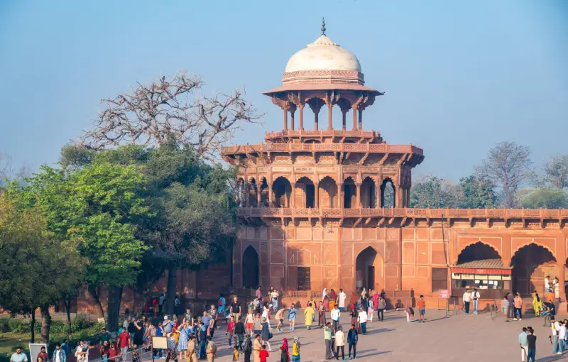 Guests touring the grand entrance of Agra Fort in India, as part of the Luxury Golden Triangle Tour, showcasing India Group Tour highlights.